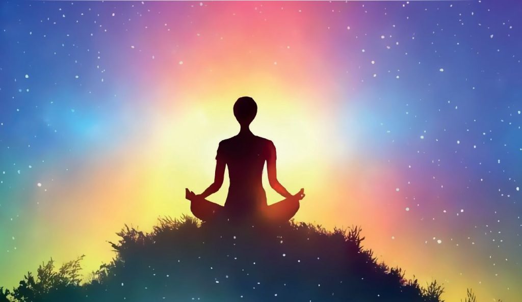 Sylwetka osoby siedzącej w pozycji medytacyjnej na wzgórzu, otoczonej świetlistą, wielobarwną aurą przechodzącą od żółci i pomarańczu do fioletu i błękitu; w tle rozgwieżdżone niebo, atmosfera spokoju, duchowości i wewnętrznej harmonii.
